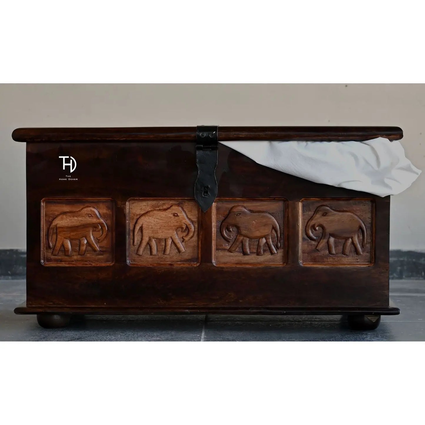Wooden trunk with elephant carvings on a Natural finish.