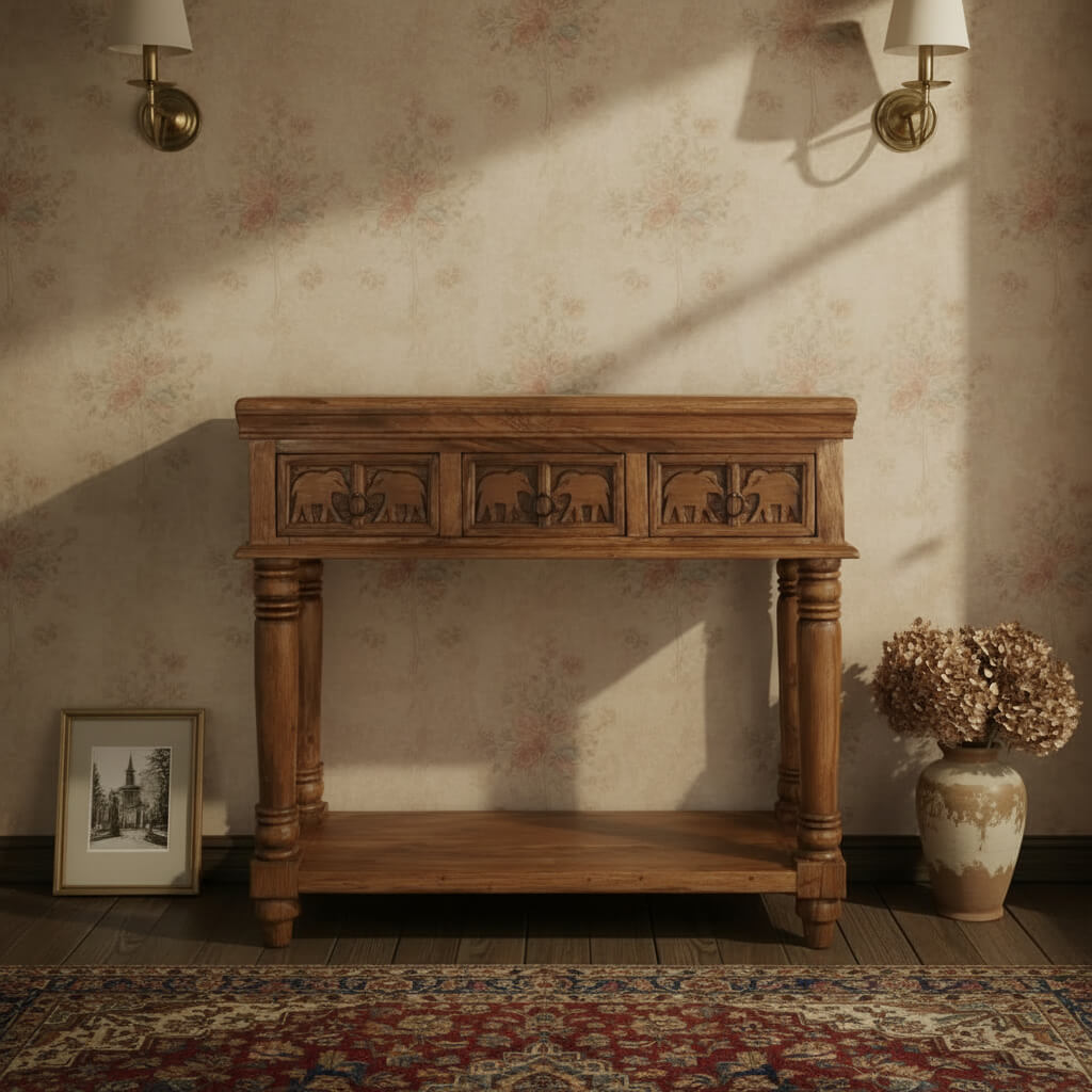 A wooden console table with three drawers and carved details, finished in a warm brown hue. With shelve at bottom.