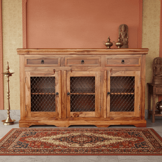 A wooden sideboard with three drawers and three doors with handmade iron jali featuring a geometric pattern.