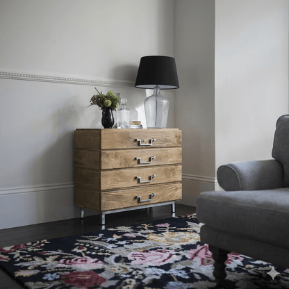 A wooden chest of 4 drawers with a stainless steel base.