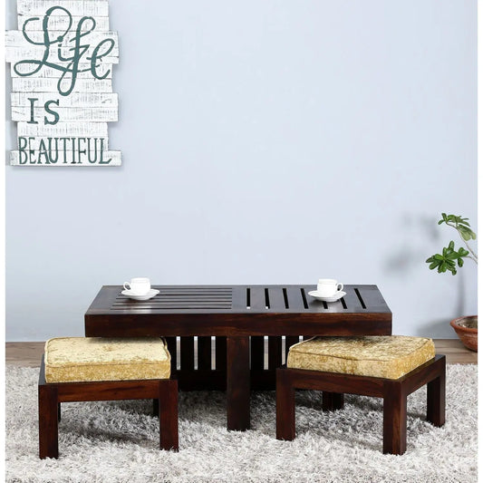 A Rectangle brown Solid sheesham wood coffee table with two cushioned stools. 