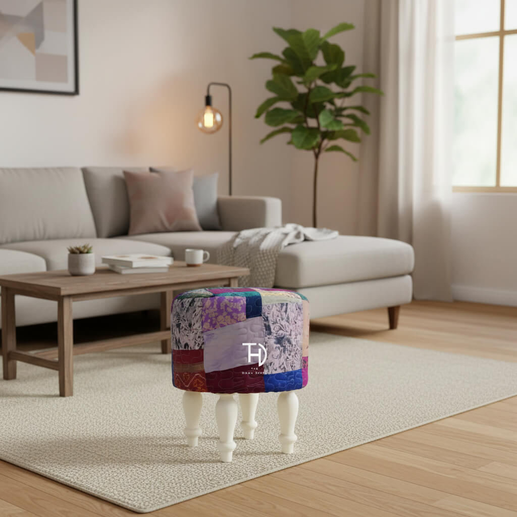 A multicolored patchwork pouf with silk upholstery on a Sheesham wood structure, with white-painted legs.