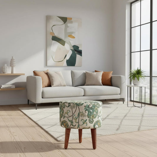 A round Cream Pouf with floral fabric design on top, supported by three wooden legs.