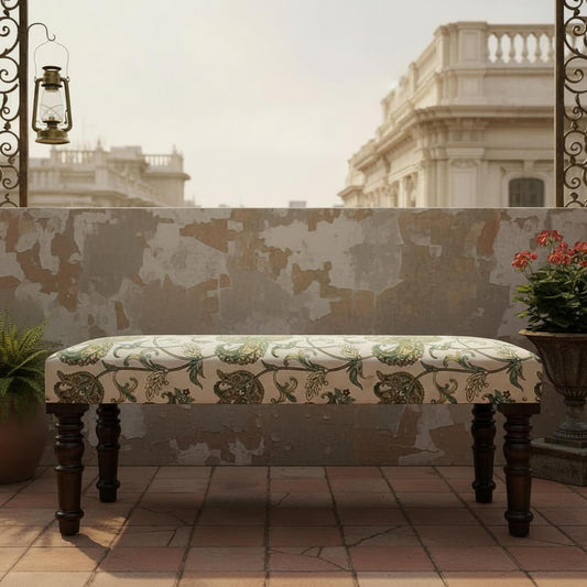 A floral upholstered bench with wooden legs.