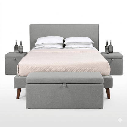 A gray upholstered storage bench at the foot of a bed, with a closed lid and a cushion on top for seating.