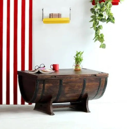 A barrel-shaped coffee table made of Sheesham wood with metal strips on the sides.