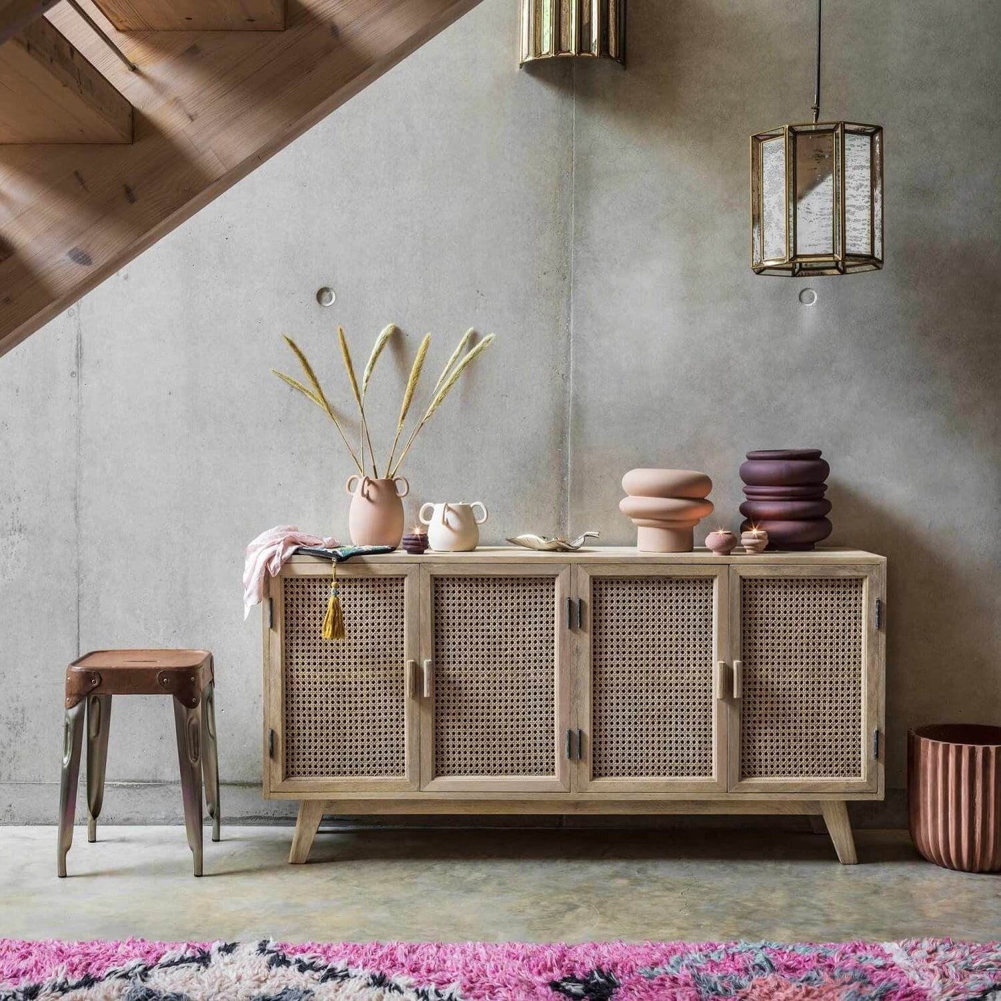 A four-door sideboard with a wicker weave design and solid mango wood construction, featuring knockdown legs.