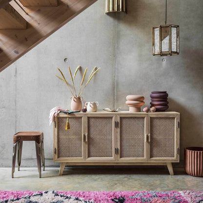 A four-door sideboard with a wicker weave design and solid mango wood construction, featuring knockdown legs.