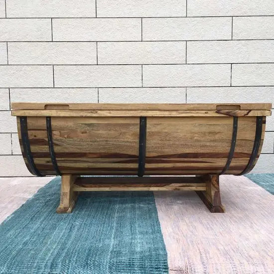 Solid wood barrel shaped coffee table with metal strips on the sides.