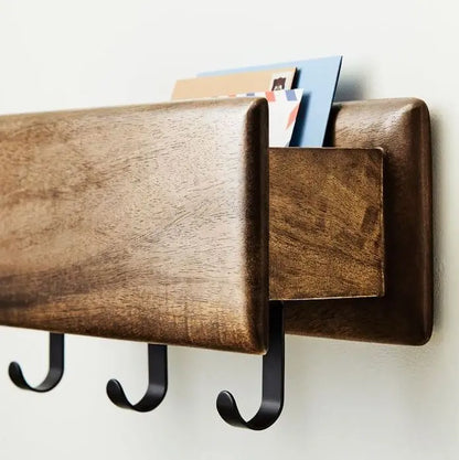Wooden wall-mounted mail organizer with three hooks holding Modern wall rack. 