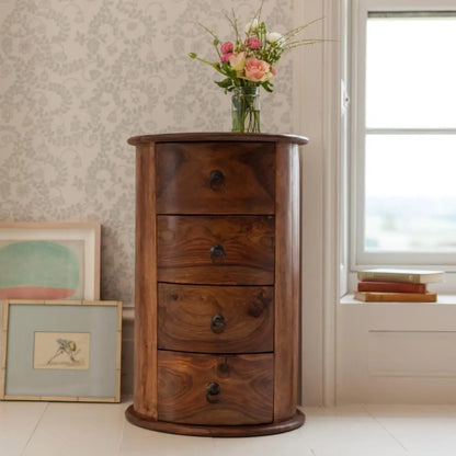 A round, brown sheesham wood side table with four drawers, featuring a natural finish. A real class of wooden furniture.