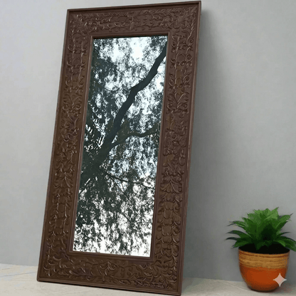 A rustic Aklavya mirror frame made of Sheesham wood with intricate hand-carved details.