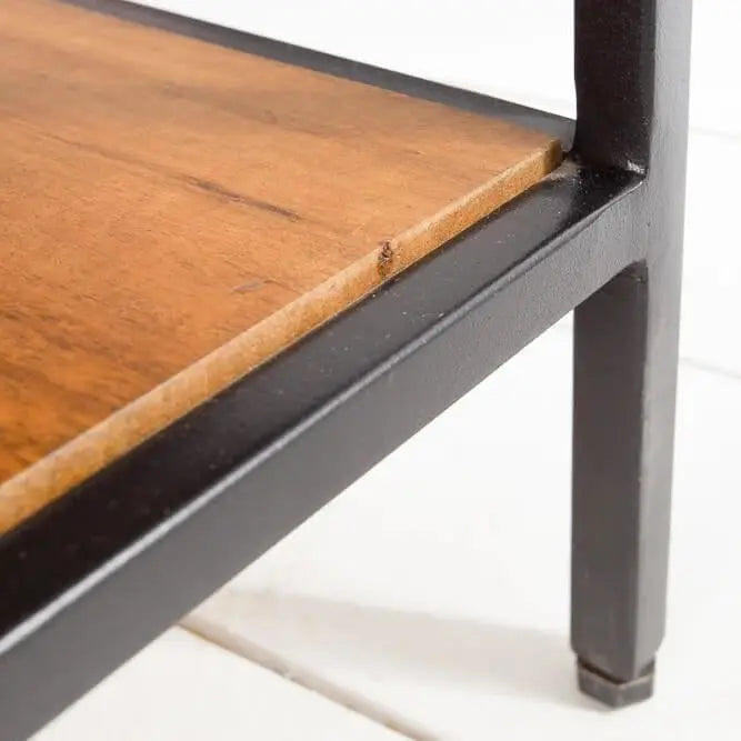 Close-up of a wooden shelf with a black metal frame.