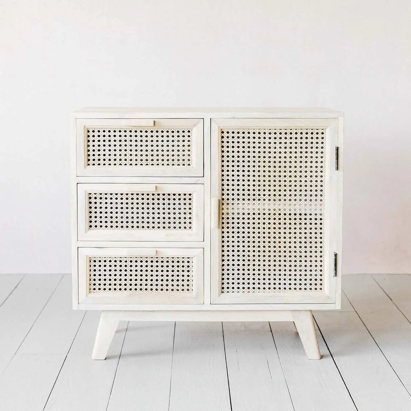 White wooden cabinet with rattan doors and drawers. 