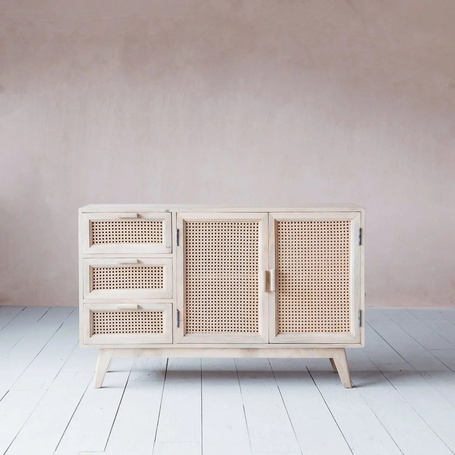 Wooden cabinet with two rattan doors and three rattan drawers.