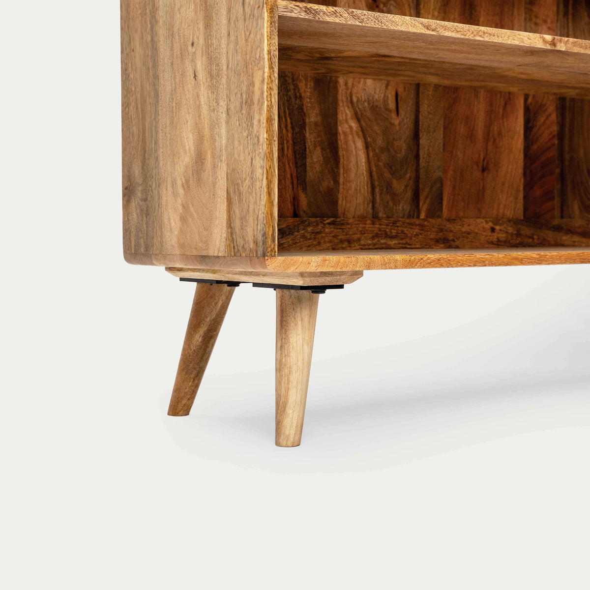 Close-up of a wooden cabinet or shelf unit with angled legs, showing the wood grain.
