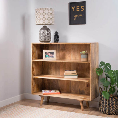 A solid wood three-tier bookshelf with tapered legs.