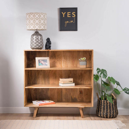 A wooden three-shelf bookcase with a warm medium-brown finish and tapered legs.