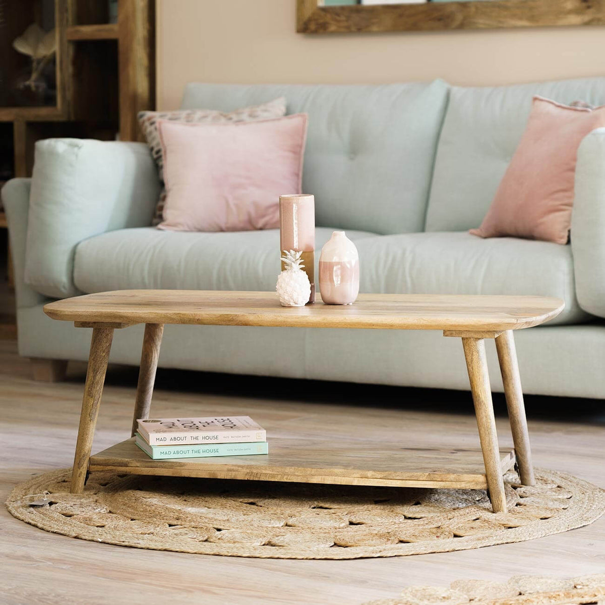A light natural wood coffee table with a lower shelf.