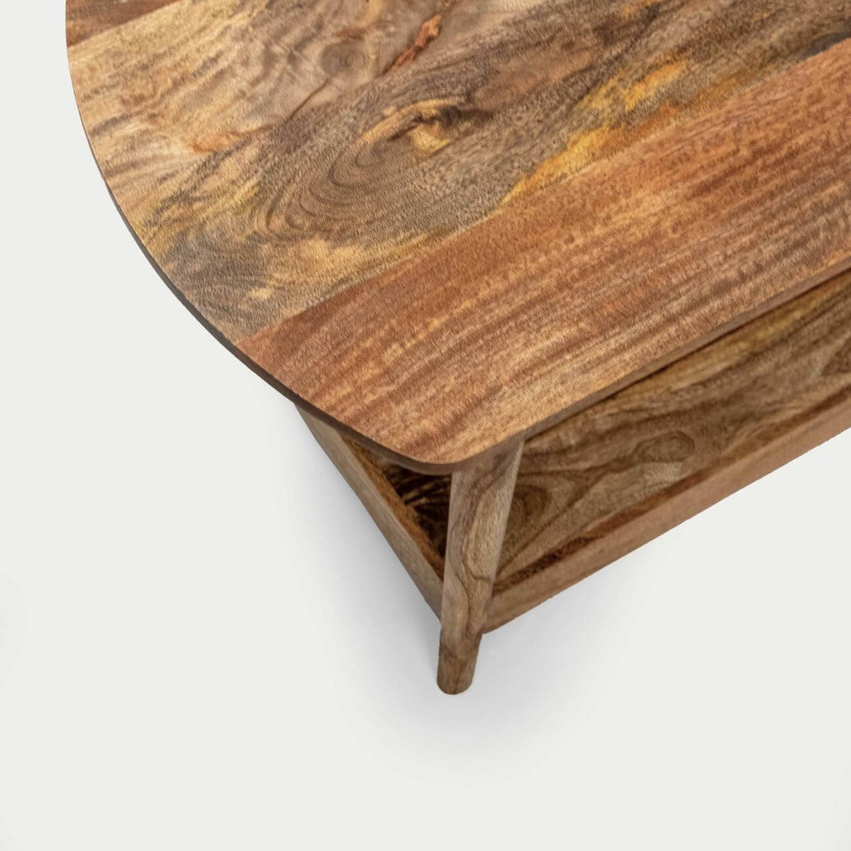 Close-up of a wooden coffee table with a rounded semicircular top, showcasing natural wood grain patterns in warm brown and tan tones.