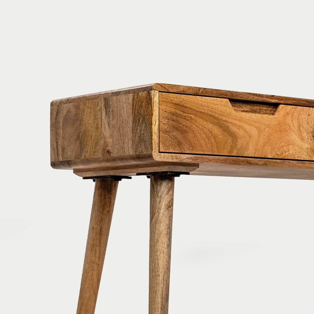 Close-up of a wooden console table showing the top corner, a drawer front with a recessed pull, and two tapered legs.