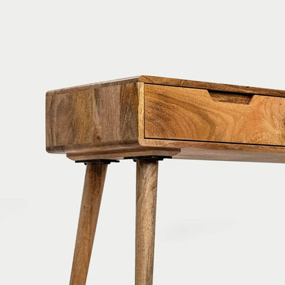 Close-up of a wooden console table showing the top corner, a drawer front with a recessed pull, and two tapered legs.
