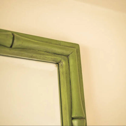 Close-up of a bamboo-style mirror frame in a muted olive green finish.