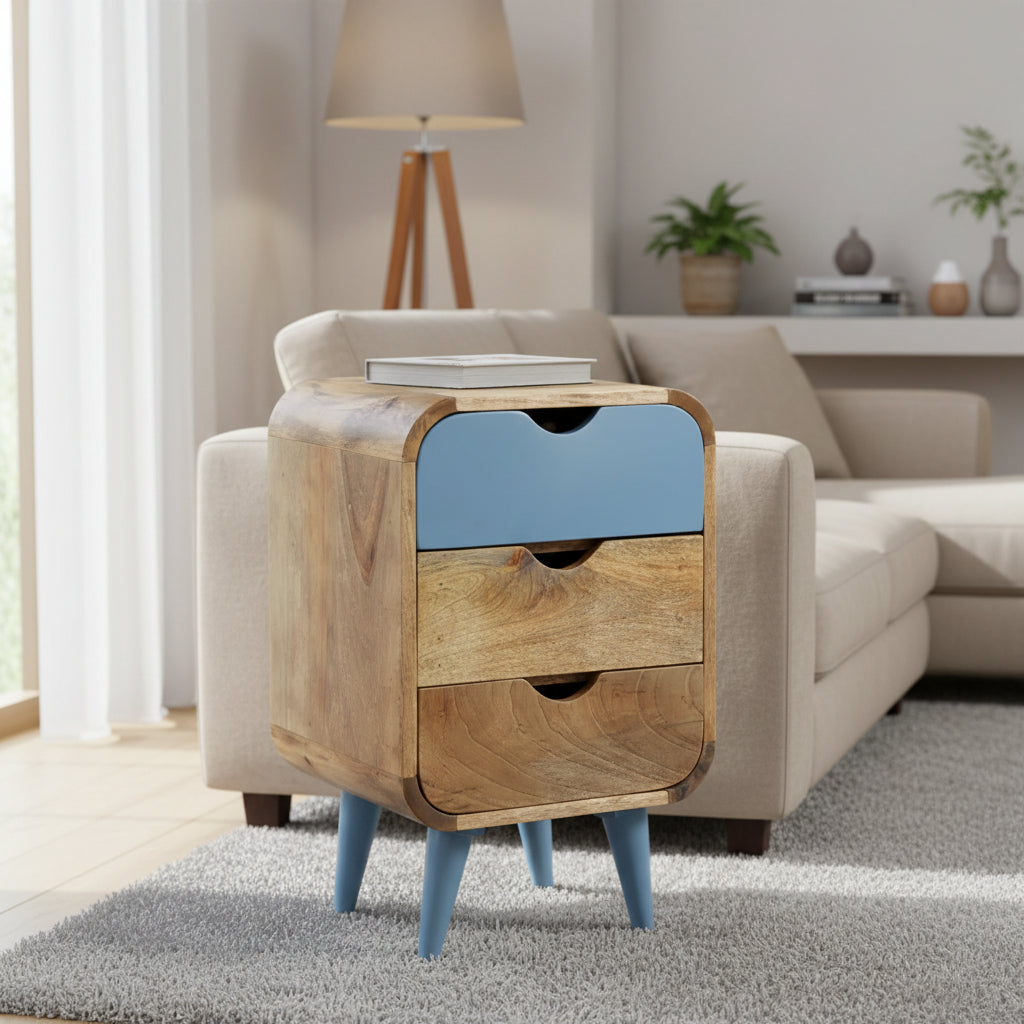 A blue bedside table made of mango wood with three drawers and pointed turned legs, the top drawer is blue and the two bottom drawers are natural wood color.