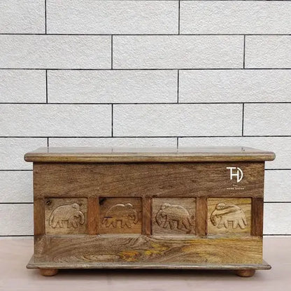 Solid wood rectangular Carob trunk mango coffee table with elephant carvings on the front.