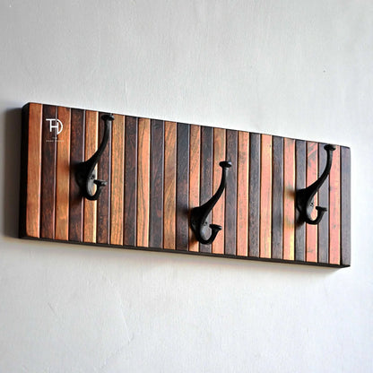 Wooden wall hook with striped design and three black hooks.