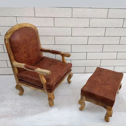A brown upholstered cushioned chair & stool with curved wooden legs and a tufted backrest.