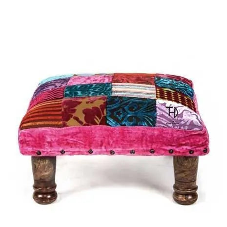 Colorful patchwork ottoman with wooden legs. 
