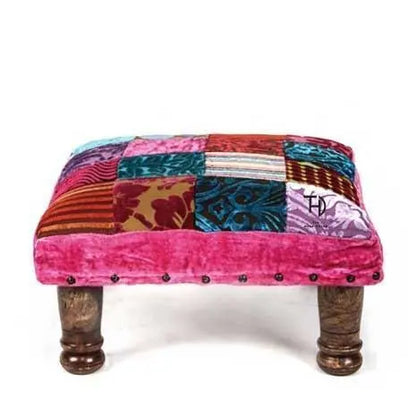 Colorful patchwork ottoman with wooden legs. 