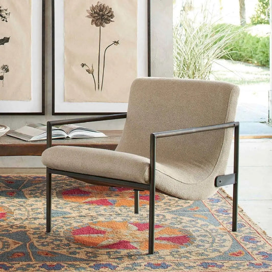 Beige armchair with black metal frame.