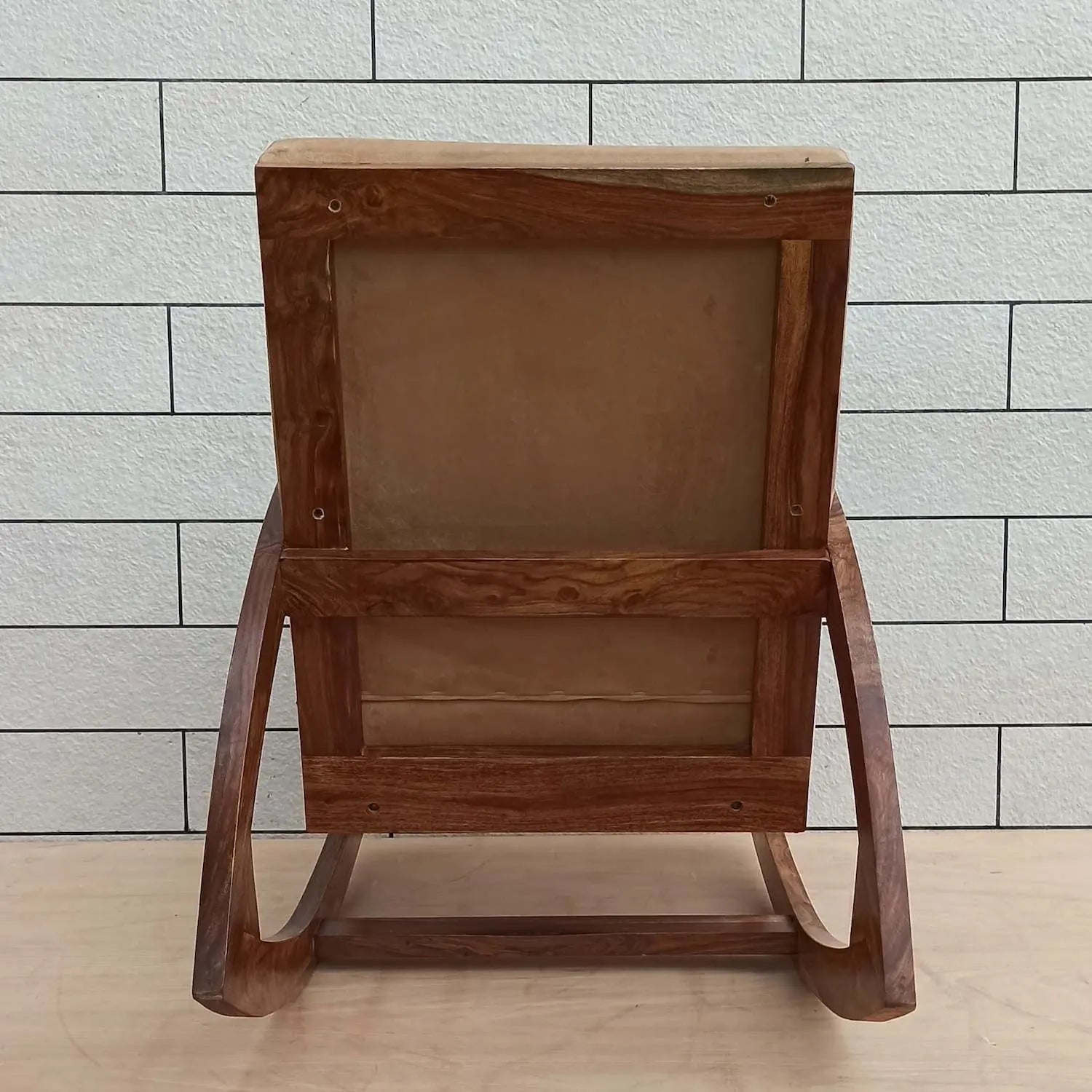 Solid sheesham wood designer rocking chair with beige cushion.