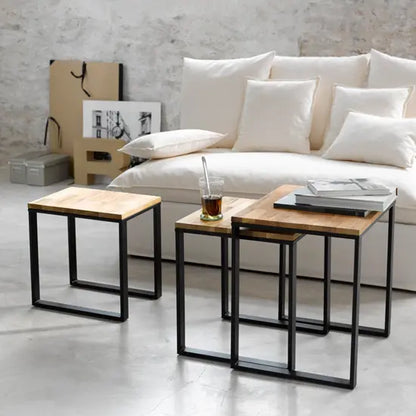 A rectangle shape set of three Devi metal stools with black legs and a mango wood top. 