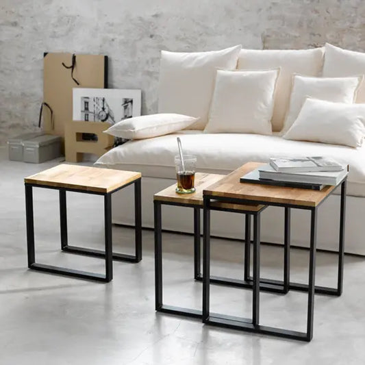 A rectangle shape set of three Devi metal stools with black legs and a mango wood top. 