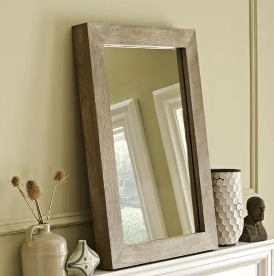 A rectangular Devi solid wood mirror frame in a natural wood color.