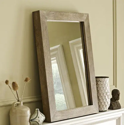 A rectangular Devi solid wood mirror frame in a natural wood color.