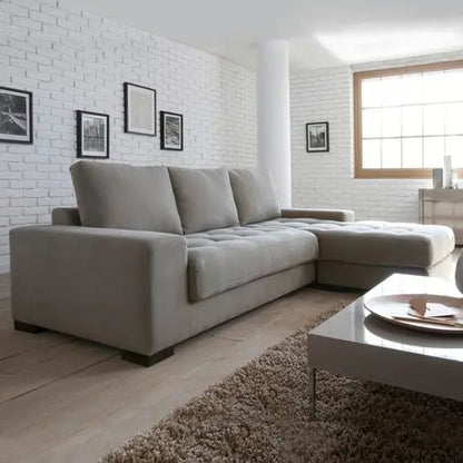 An L-shaped sofa in a living room setting with a modern design, light gray fabric, and wooden sofa Structure.