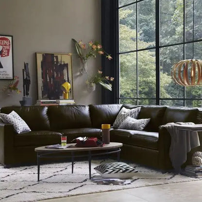 An oval-shaped mango wood top coffee table with a hammered iron base.