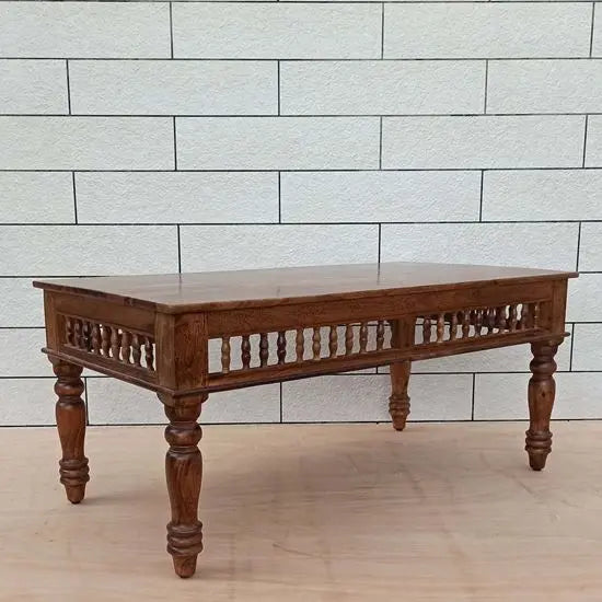 A traditional rectangular coffee table made of Sheesham wood with turned legs and a natural wood finish.