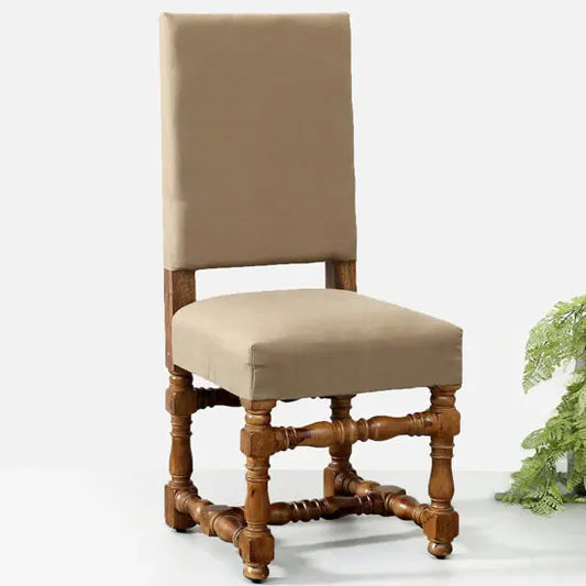 A beige upholstered chair with a wooden frame and intricate detailing, likely a traditional or antique style chair.
