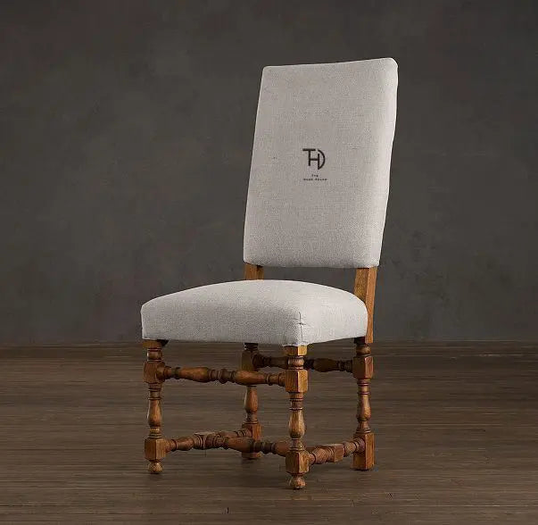 Chair with wooden frame and light gray upholstered seat and backrest cushioned.  