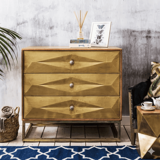 A brass-painted chest of drawers with three drawers, featuring a geometric design on the drawer fronts. Export Quality furniture product.