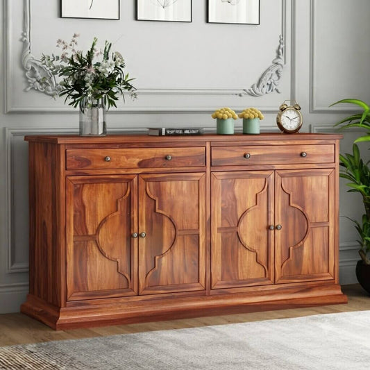 A warm brown wooden sideboard or credenza with ornate carved panel doors and small round metal knobs.