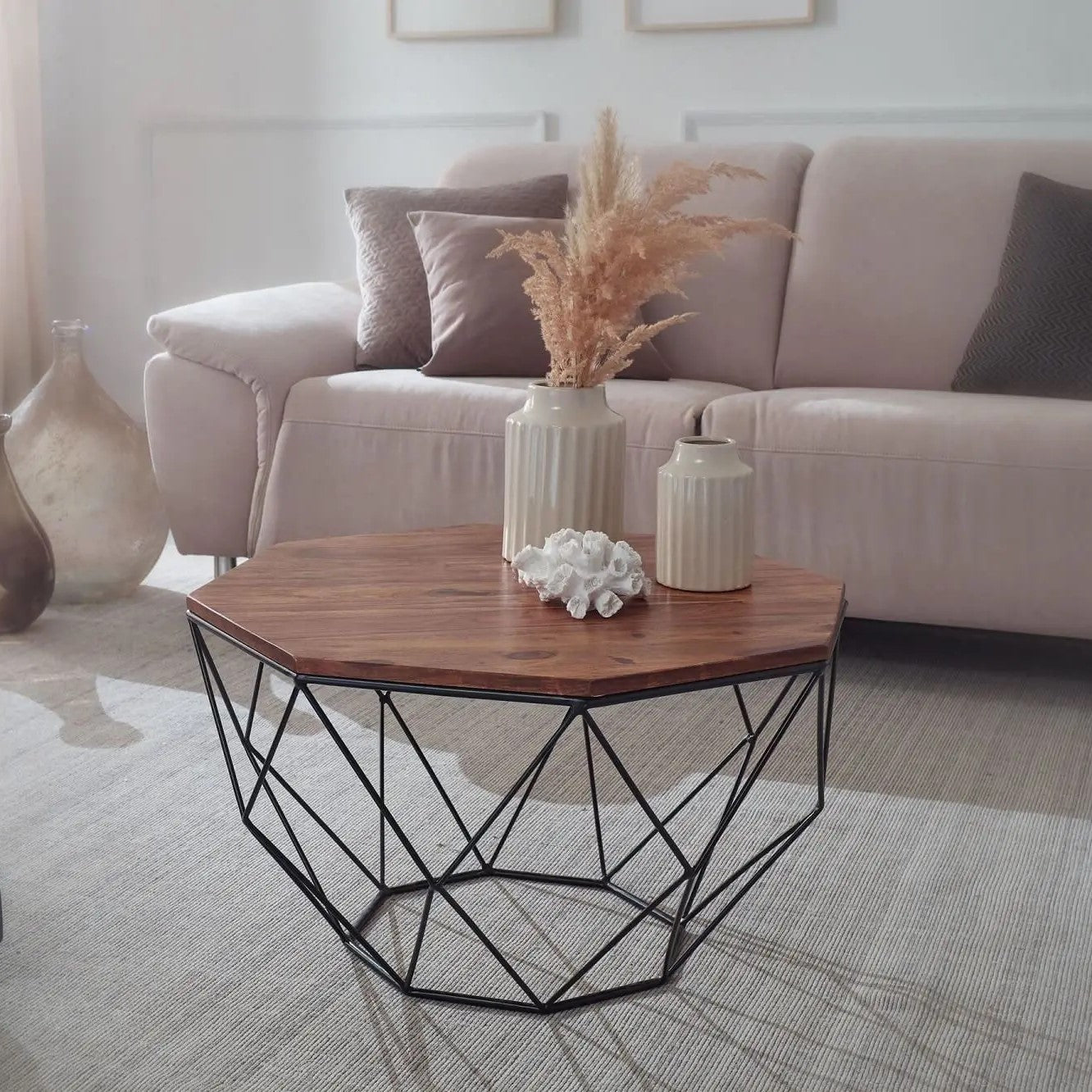 A Hexagonal brown coffee table with a geometric black metal base.