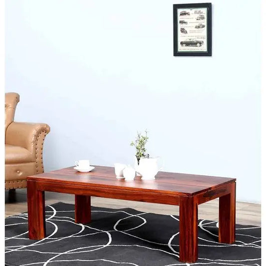 A rectangular redish wooden coffee table made in Solid sheesham wood.  