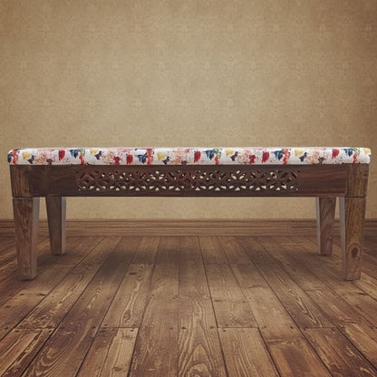 A wooden bench with off white color cushion covered in soft fabric with a floral pattern.