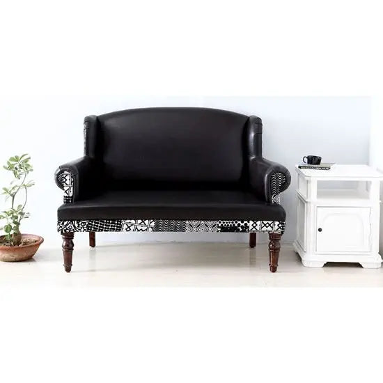 A black Maharani 2 seater sofa with rexine and velvet touch fabric, featuring round front legs with walnut color.